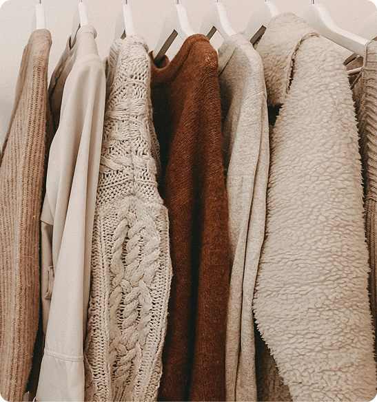 Image with multiple pieces of clothing on hangers in a row